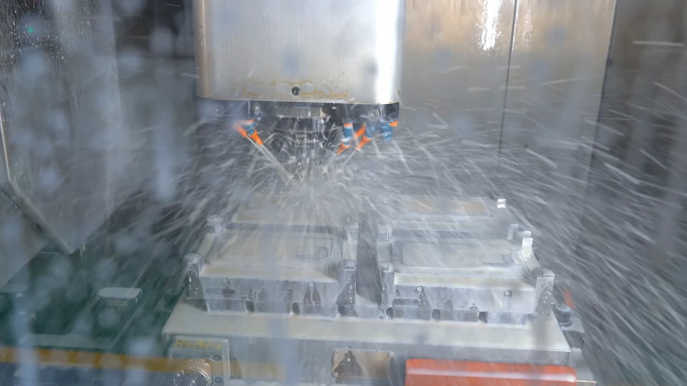 CNC machine cutting a steel injection mold cavity block
