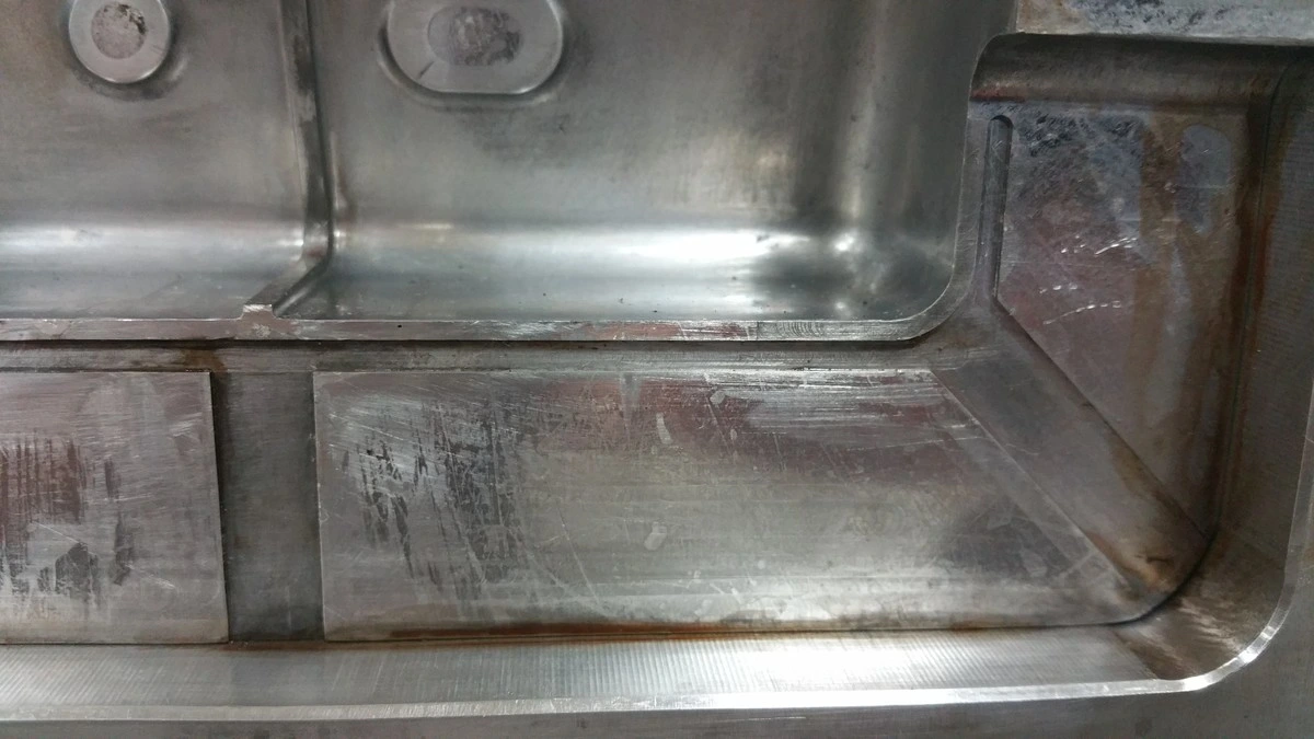 Close-up of an injection mold cavity insert showing parting line vents