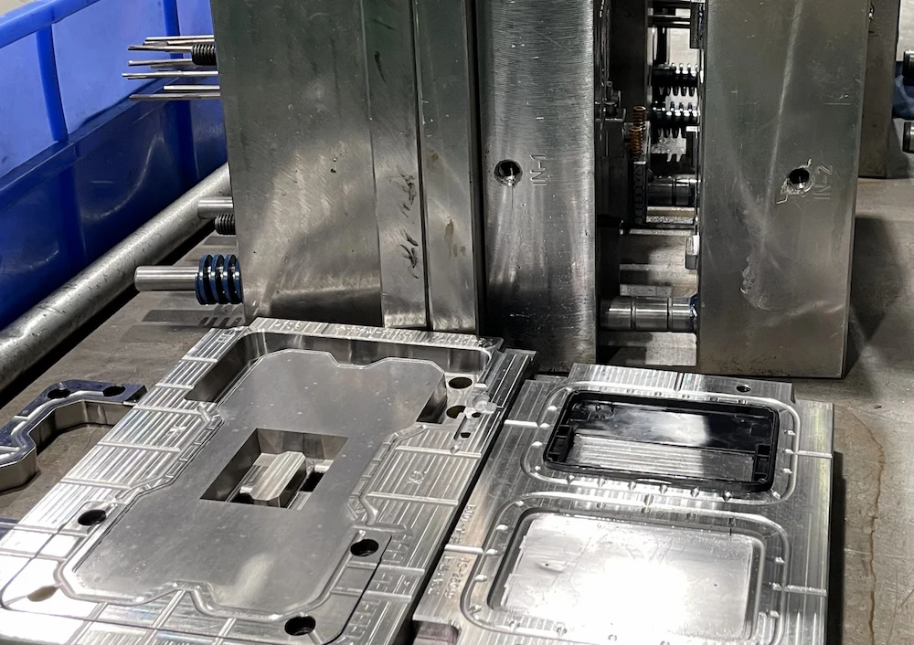 Open multi-cavity injection mold showing identical part cavities