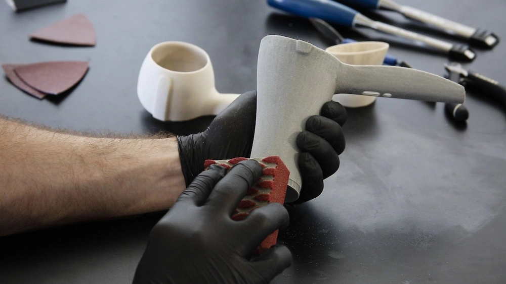 Technician sanding and post-processing a 3D printed plastic part