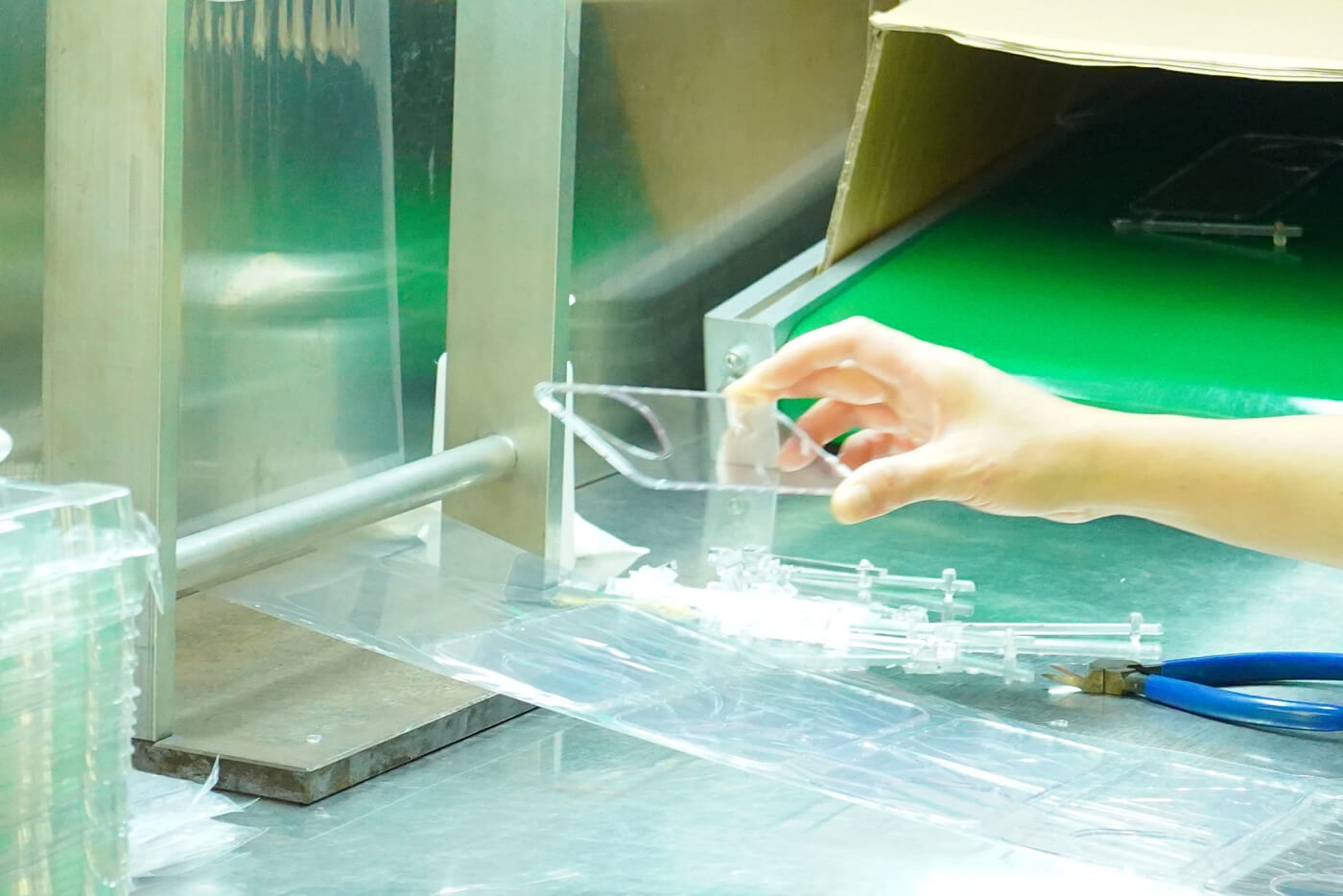 Technician inspecting a clear plastic part for haze under bright light