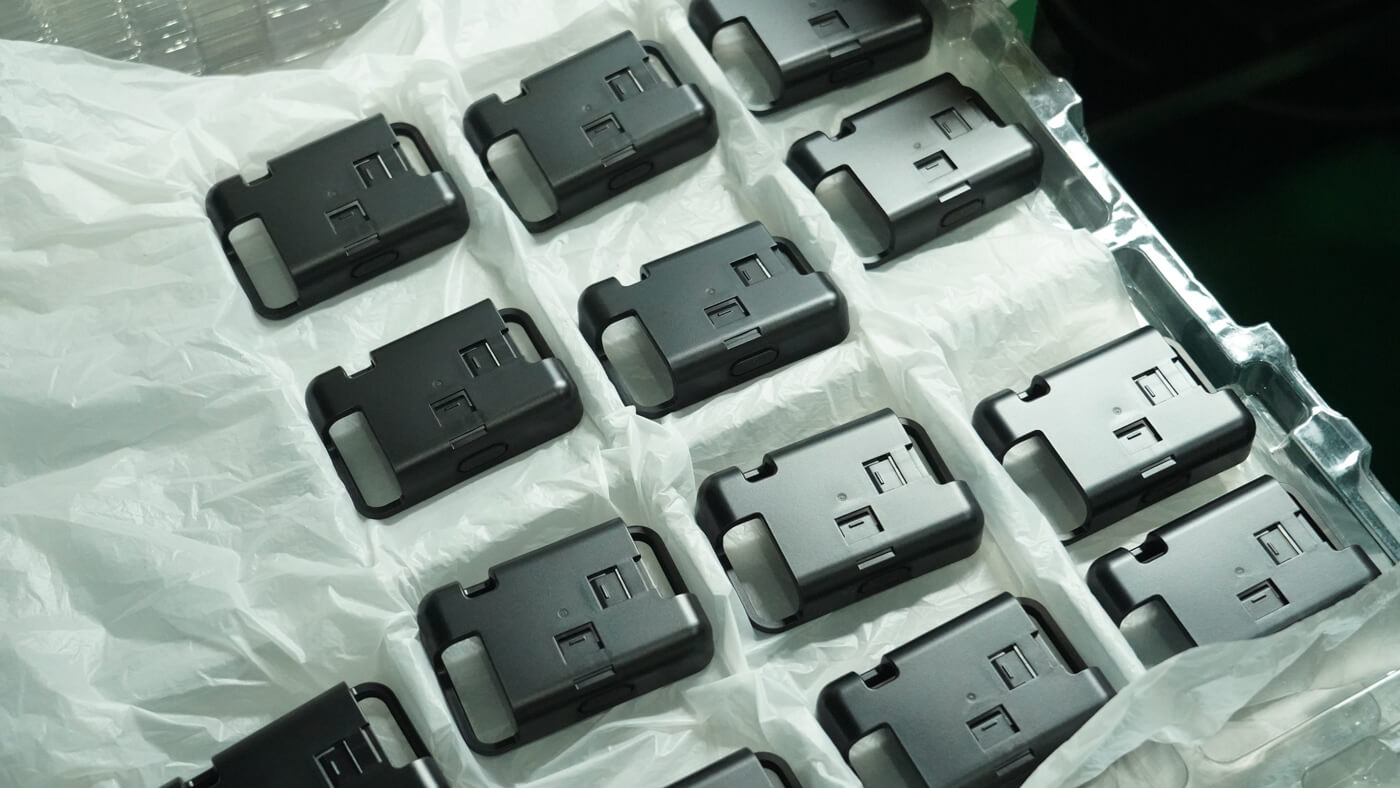 Freshly molded plastic parts arranged in a tray on a factory inspection table