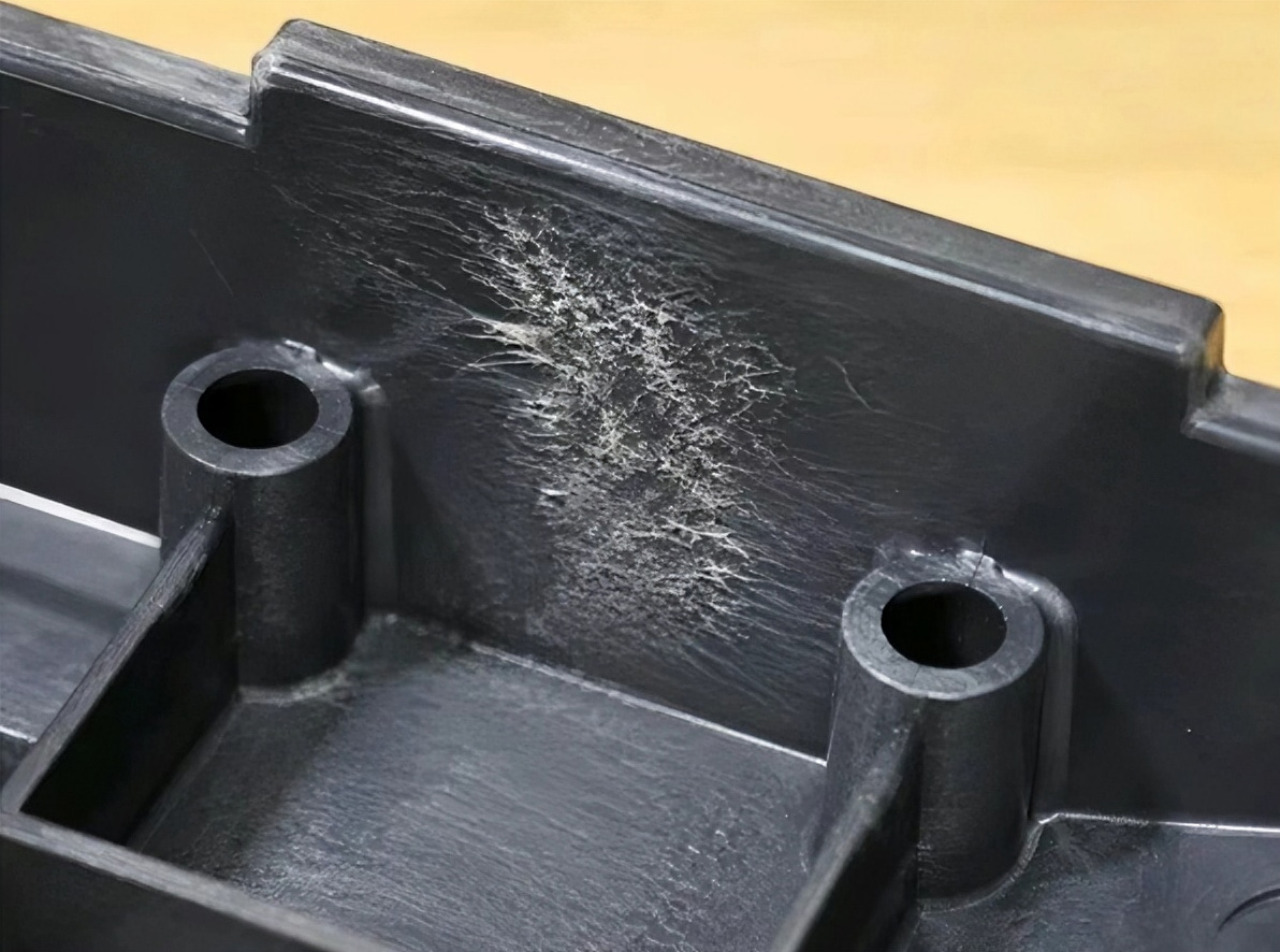 Close-up of a glass fiber reinforced plastic part showing visible surface swirl marks