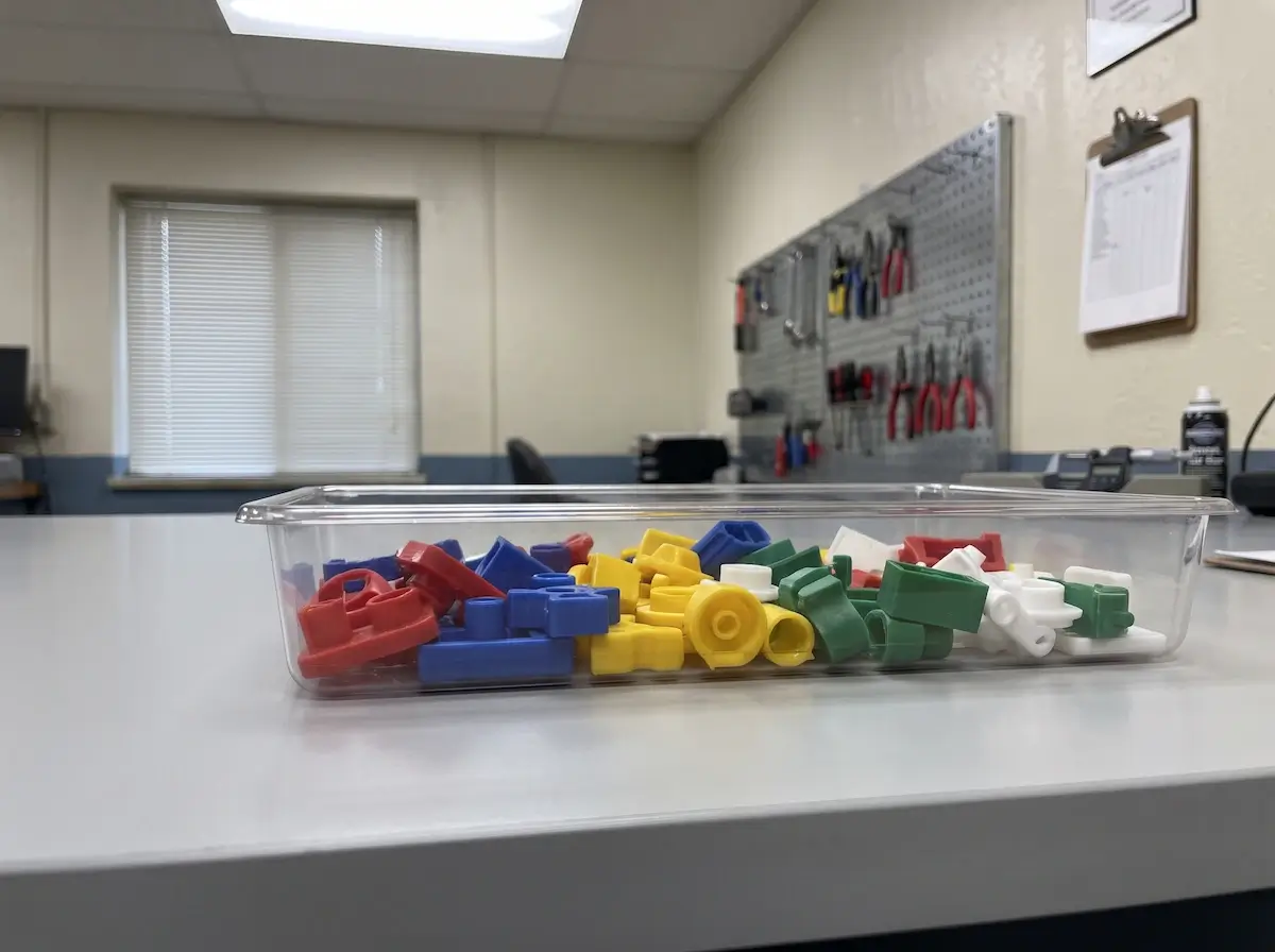 A tray of injection molded thermoplastic sample parts in different colors