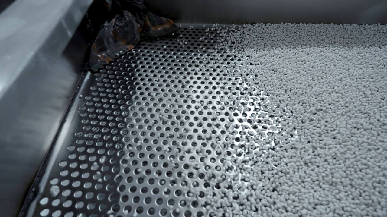 White plastic pellets and polymer granules on an industrial production line