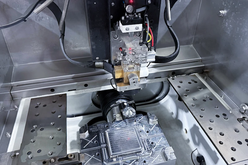 Wire EDM machine precision cutting a mold insert