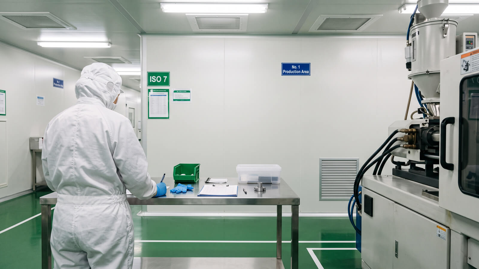 ISO Class 8 cleanroom at YG Tech with gowned technicians operating LSR injection molding equipment