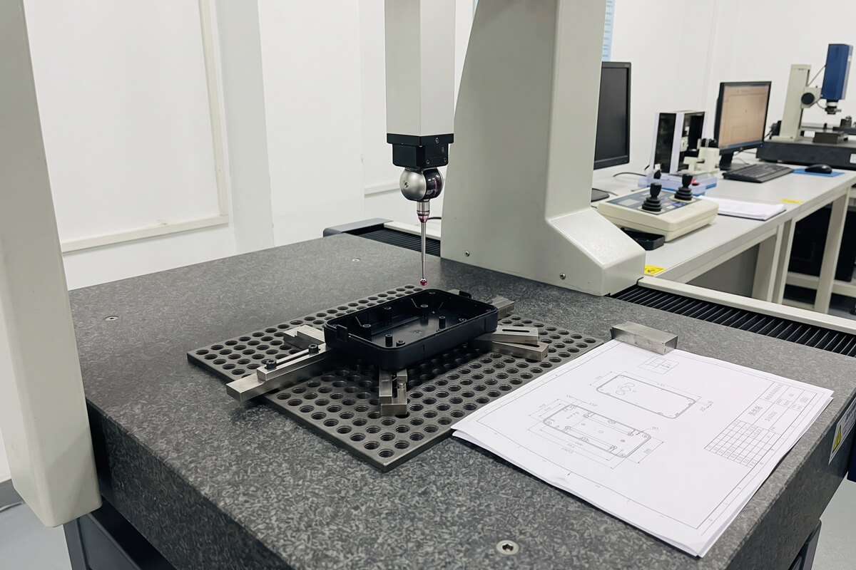 Molded plastic part clamped in an inspection fixture on a coordinate measuring machine table for dimensional verification