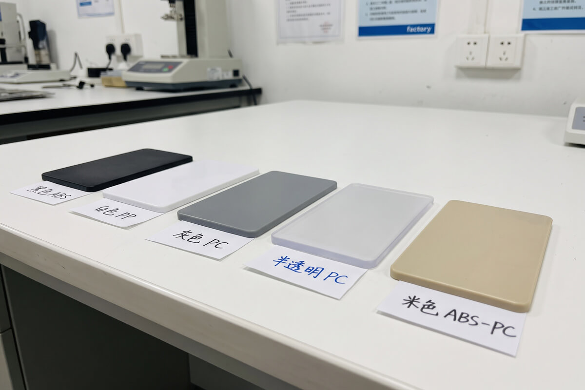 Row of molded resin test plaques in different materials lined up on a table to compare shrinkage
